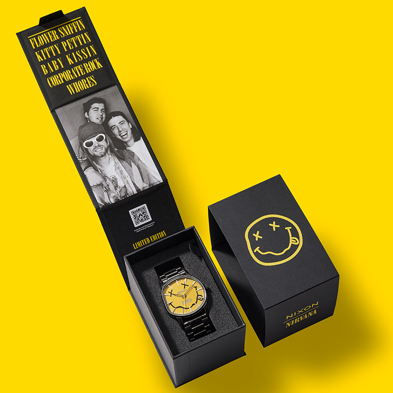 Nixon x Nirvana limited edition watch in black packaging with band photo and yellow smiley face logo.